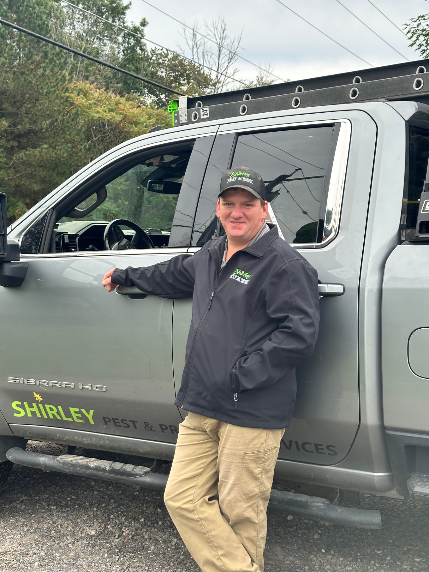 Eric Shirley, owner of Shirley Pest and Property, leaning against his branded service truck